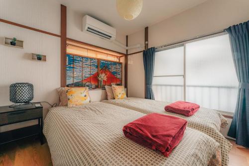 a bedroom with a bed with red pillows on it at 京急蒲田駅徒歩近の静かなモダンハウス in Tokyo