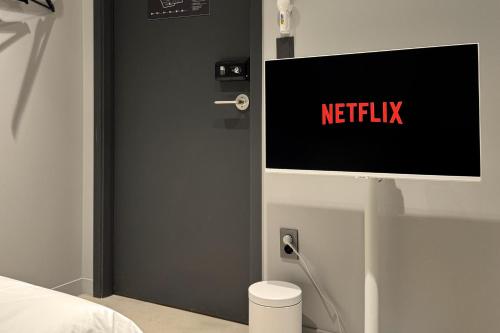 a door with a netflix sign on it in a bedroom at Original Backpackers in Seoul