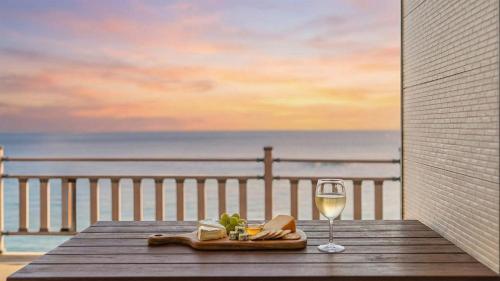 a table with a glass of wine and a plate of food at GoSeong Beach Jin Spa Pension in Goseong