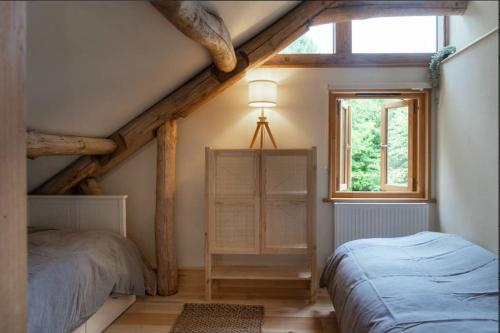 a attic bedroom with two beds and a window at Journeyman in Bromyard