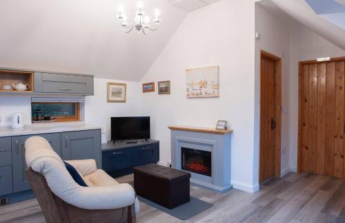 a living room with a couch and a fireplace at Dartmoor Barn on North Hessary Tor in Yelverton