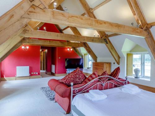 a large room with a bed and a red wall at Henrhiw Farm House at Henrhiw Farm Cottages in Usk