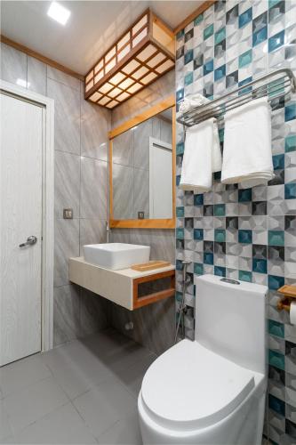 a bathroom with a toilet and a sink at Rivethi Veyli Ukulhas in Ukulhas