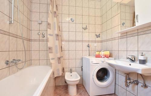 a bathroom with a toilet sink and a washing machine at Villa Cascata in Trilj