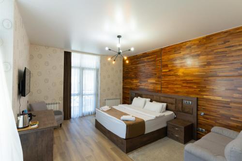 a bedroom with a large bed and a wooden wall at IREPALACE Goderdzi in Goderdzi