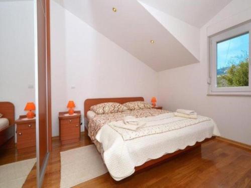 a bedroom with a bed and two nightstands and a window at Apartment Franka in Kaštela