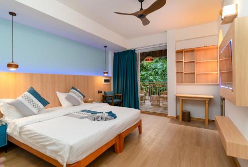 a bedroom with a bed in a room with a window at Rivethi Veyli Ukulhas in Ukulhas