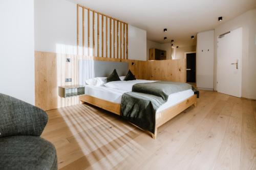a bedroom with a large bed and a couch at Stricker Aparthotel in Tirolo