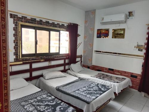 two beds in a room with a window at Four Seasons Hotel in Hurghada