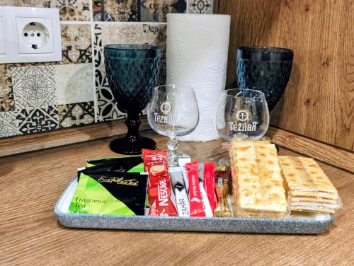 un vassoio con cracker e bicchieri di vino su un tavolo di Apartament a Chişinău