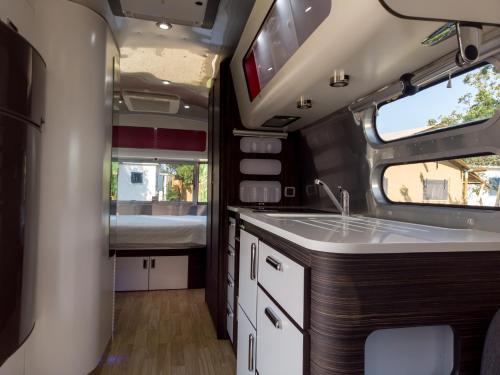 a kitchen in an rv with a sink and a bed at Procida Camp & Resort - La Caravella in Procida