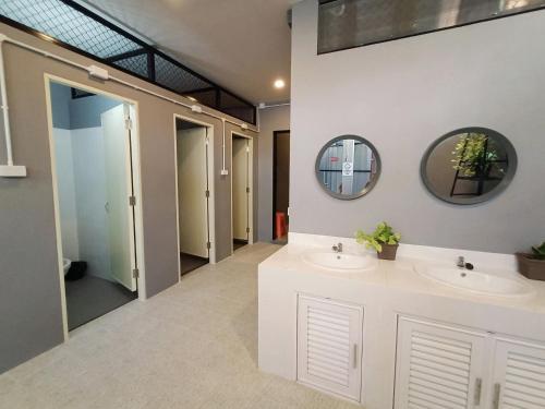 a bathroom with two sinks and two mirrors at Thesleeperhomestay in Ban Chuk Kum