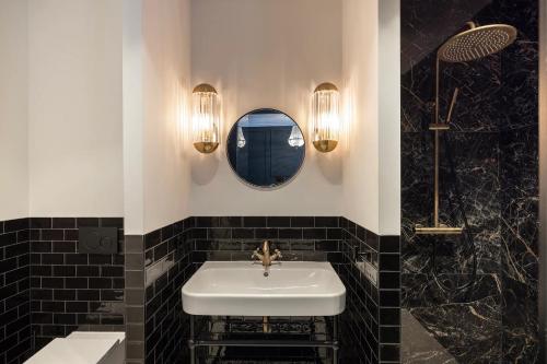 a bathroom with a white sink and a mirror at Steenhof Residence Warmond in Warmond
