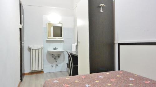 un piccolo bagno con lavandino e letto di Hotel Arno a Milano