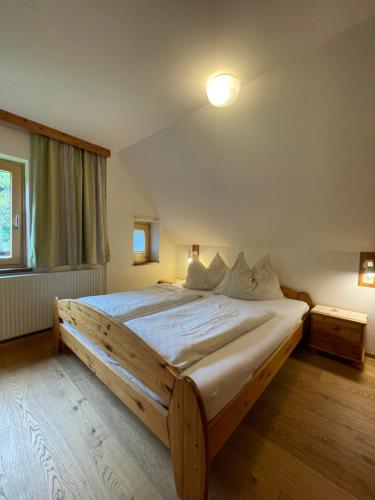 a bedroom with a large wooden bed with white sheets at Ferienhaus Julia in Admont