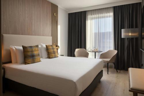 a hotel room with a large bed and a window at AC Hotel by Marriott Inverness in Inverness