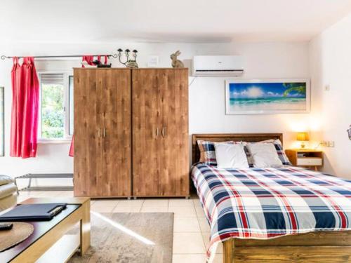 a bedroom with a bed and a wooden cabinet at Cute apartment hagoshrim in HaGoshrim