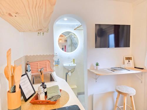 a kitchen with a table and a counter with a sink at Le Balinais - Esprit Bali, Centre-ville & Unique in Saint-Brieuc