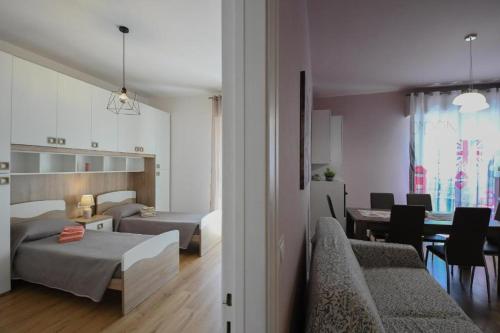 a bedroom with two beds and a dining room at Affitti brevi Liguria - La Conchiglia in Savona