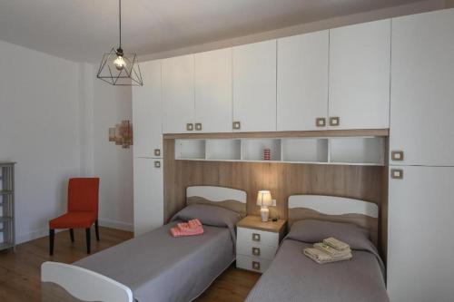 a bedroom with two beds and a table and a chair at Affitti brevi Liguria - La Conchiglia in Savona