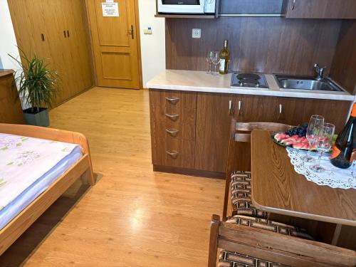 a kitchen with a sink and a table with a bowl of fruit at Penzion Hamštejn in Koberovy