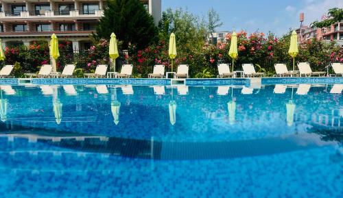 a large swimming pool with chairs and umbrellas at Diamond Palace in Sunny Beach