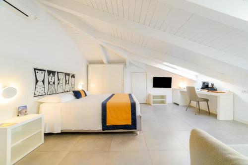 a white bedroom with a bed and a desk at Zia Pupetta Suites in Amalfi