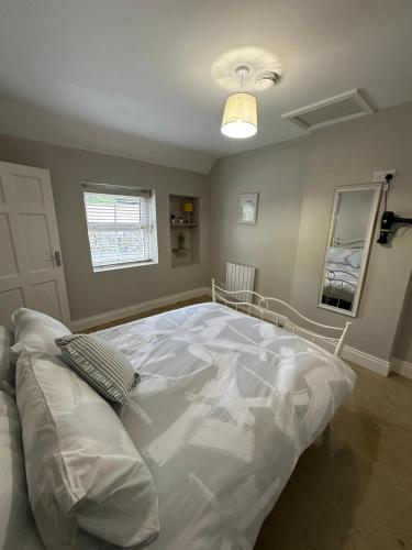 a large white bed in a room with a window at Riverside Cottage in Kildare
