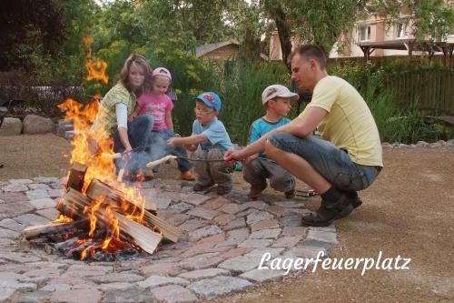 a group of children playing around a campfire at Ferienwohnungen Margaretenhof am Plauer See in Brandenburg an der Havel