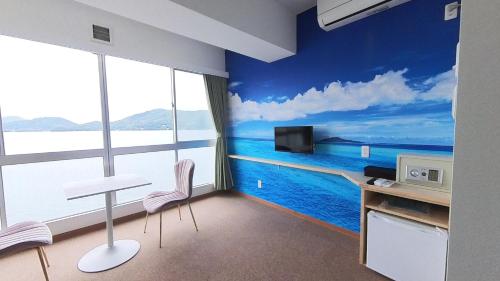 a room with a wall mural of the ocean at 森口屋アートスクエア in Shodoshima