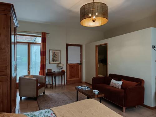 a living room with a couch and a table at LE JARDIN DU ROSSIGNOL in Willeman