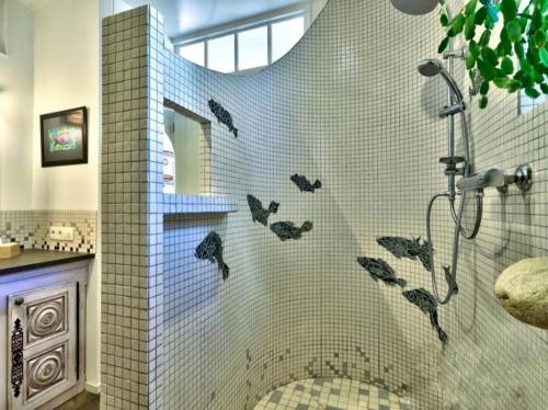 a bathroom with a shower with butterflies on the wall at L'écurie Kerdoel in Cléder