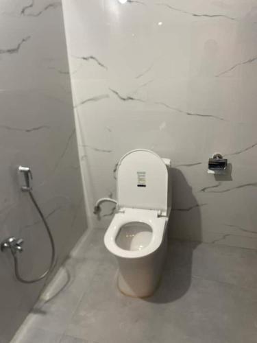 a bathroom with a white toilet in a stall at CASA Lasa Beach view in Kālapettai