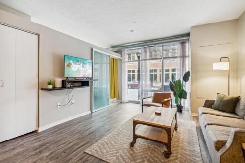 a living room with a couch and a table at CozySuites Mill District with pool, gym #02 in Minneapolis