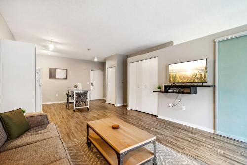 a living room with a couch and a table at CozySuites Mill District with pool, gym #02 in Minneapolis