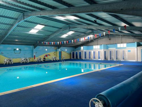 a large swimming pool in a large building at Macs Shack, Two bed Chalet on California Sands Holiday Park - Sleeps 5, pet friendly, includes FREE pool passes - plus bed linen and towels included - only 300m from the beach! in Great Yarmouth