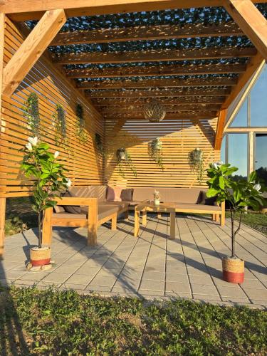 a wooden patio with two benches and a table at Harmony Cottage - Private Jacuzzi & Nature in Banja Luka