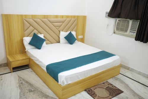 a bed with blue pillows in a room at HOTEL chandra garden in Govardhan