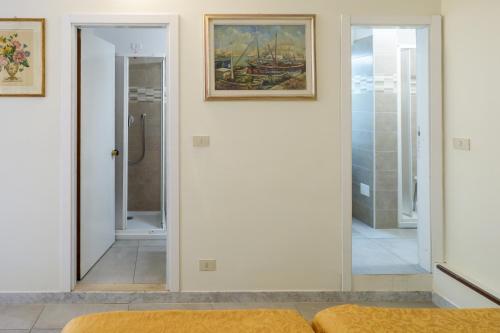 ein Schlafzimmer mit Spiegel und ein Badezimmer mit Dusche in der Unterkunft Hotel Delta Florence in Calenzano