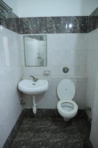a bathroom with a toilet and a sink at HOTEL chandra garden in Govardhan
