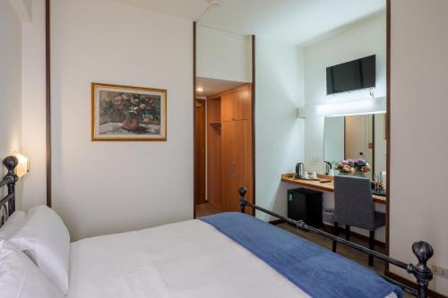 ein Schlafzimmer mit einem Bett und einem Schreibtisch mit Computer in der Unterkunft Hotel Delta Florence in Calenzano
