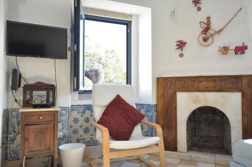 a living room with a chair and a fireplace at Casota in Sintra