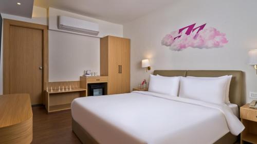 a bedroom with a large white bed in a room at Regenta Z Vadodara in Vadodara
