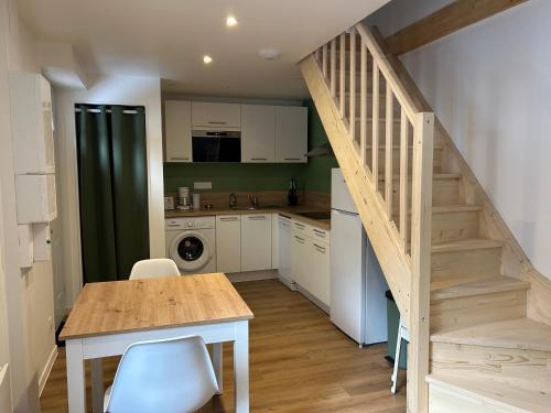 une cuisine avec une table en bois et un escalier dans l'établissement Les Coteaux, à Gérardmer