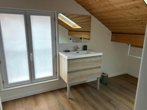 une salle de bain avec un lavabo et deux fenêtres dans l'établissement Les Coteaux, à Gérardmer