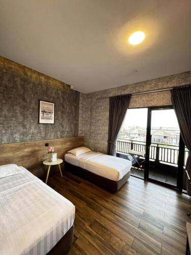 a hotel room with two beds and a balcony at Cube Bed Station & Tours Sdn Bhd in Semporna