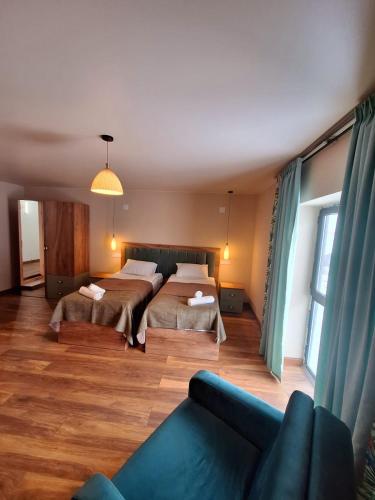 a living room with two beds and a couch at Hotel-restaurant Stumari in Ushguli