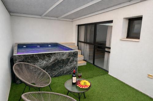 a pool with two chairs and a table with a bottle of wine at פסגת הגליל - סוויטות רומנטיות לחופשה זוגית in Manot