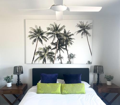 a bedroom with a bed with palm trees above it at Plantation Hotel Coffs Harbour in Coffs Harbour