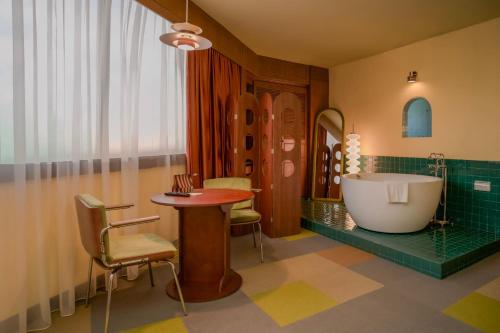a bathroom with a bath tub and a table and a bath tub at The Très Hotel in Kuala Lumpur
